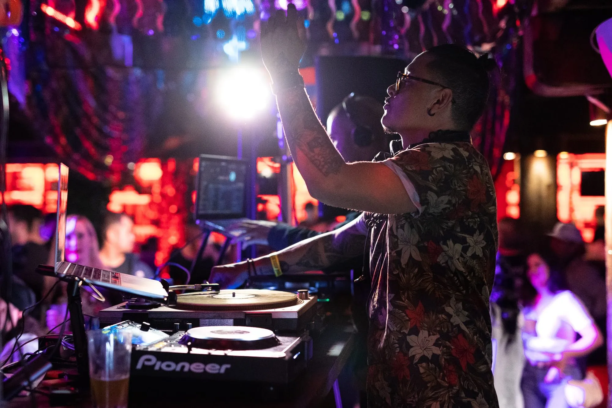 DJ CMAN arms raised behind the decks at a Soul of Sydney club night