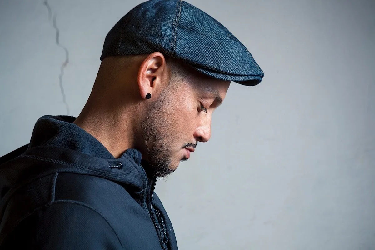 DJ CMAN portrait in a flat cap, side profile — Sydney DJ