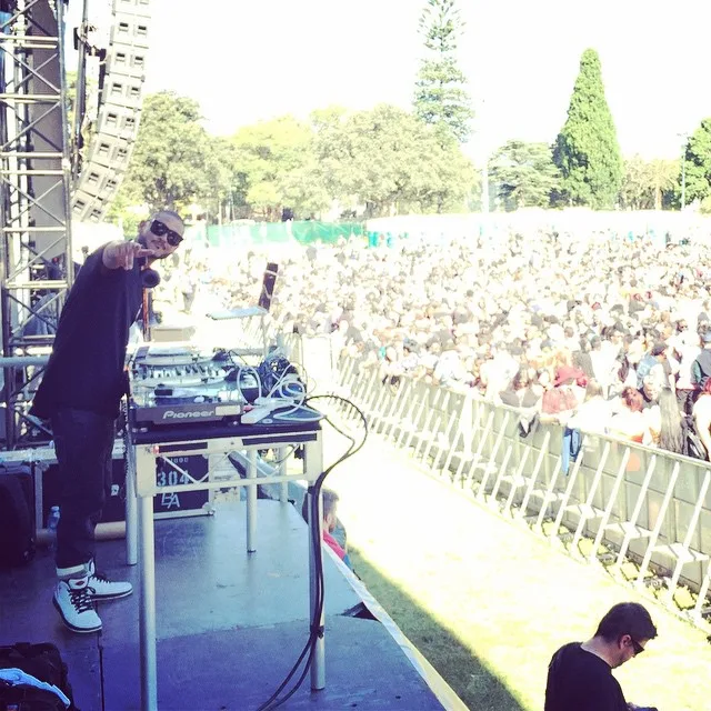 DJ CMAN pointing out to a daytime festival crowd from the stage