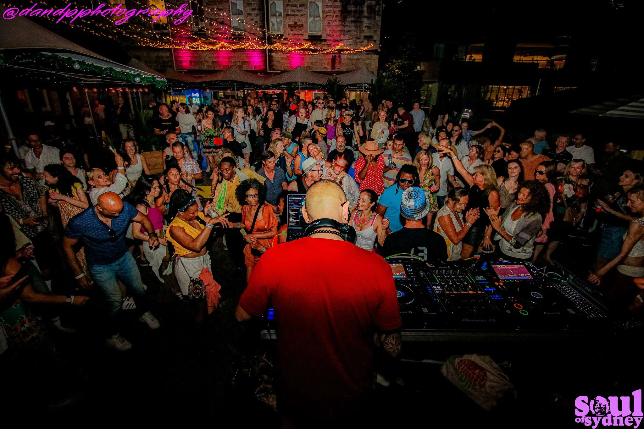 DJ CMAN DJing to a packed dancefloor at a Soul of Sydney block party at night