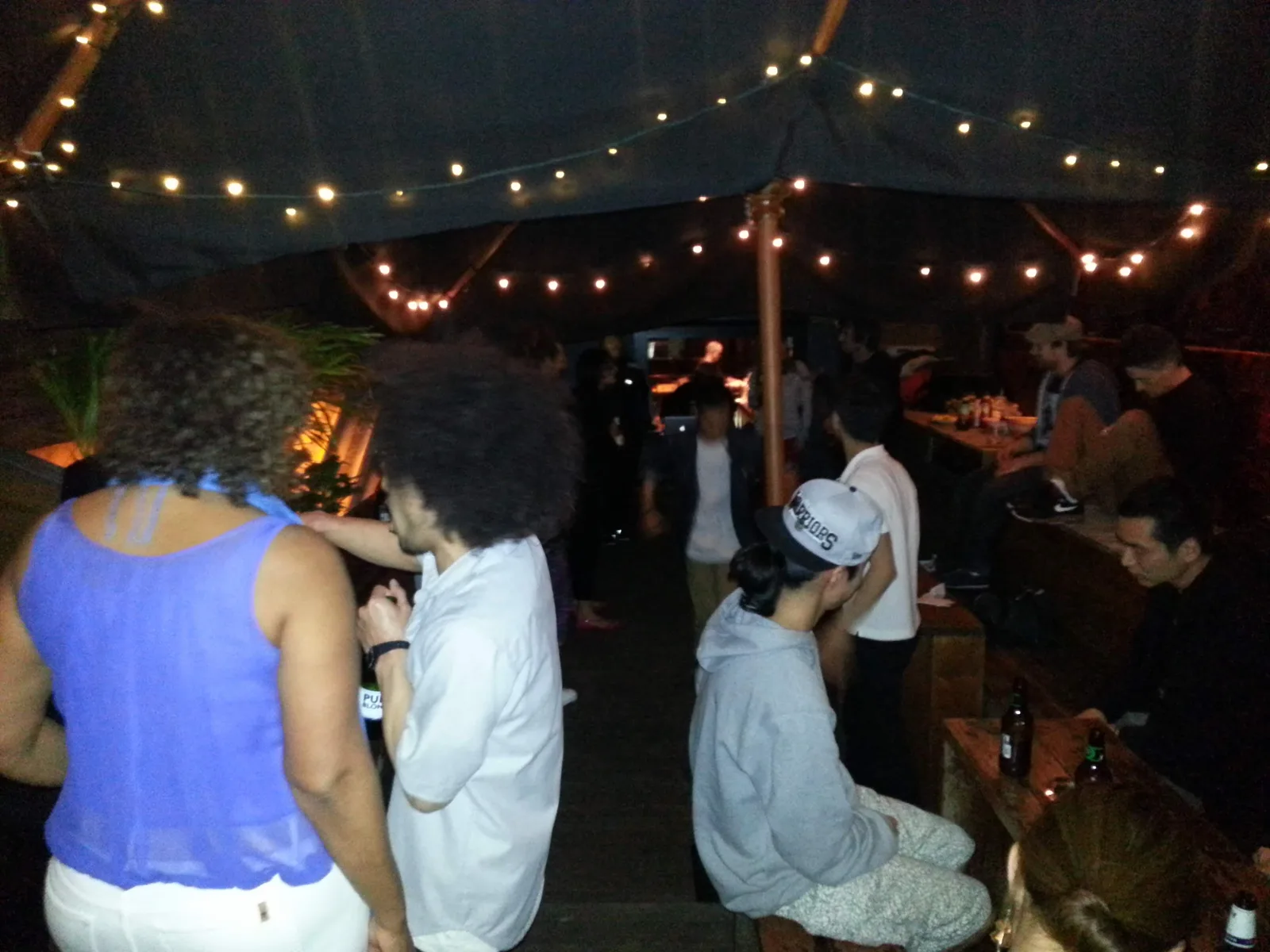 Crowd standing in the courtyard at Ching-a-Lings under string lights