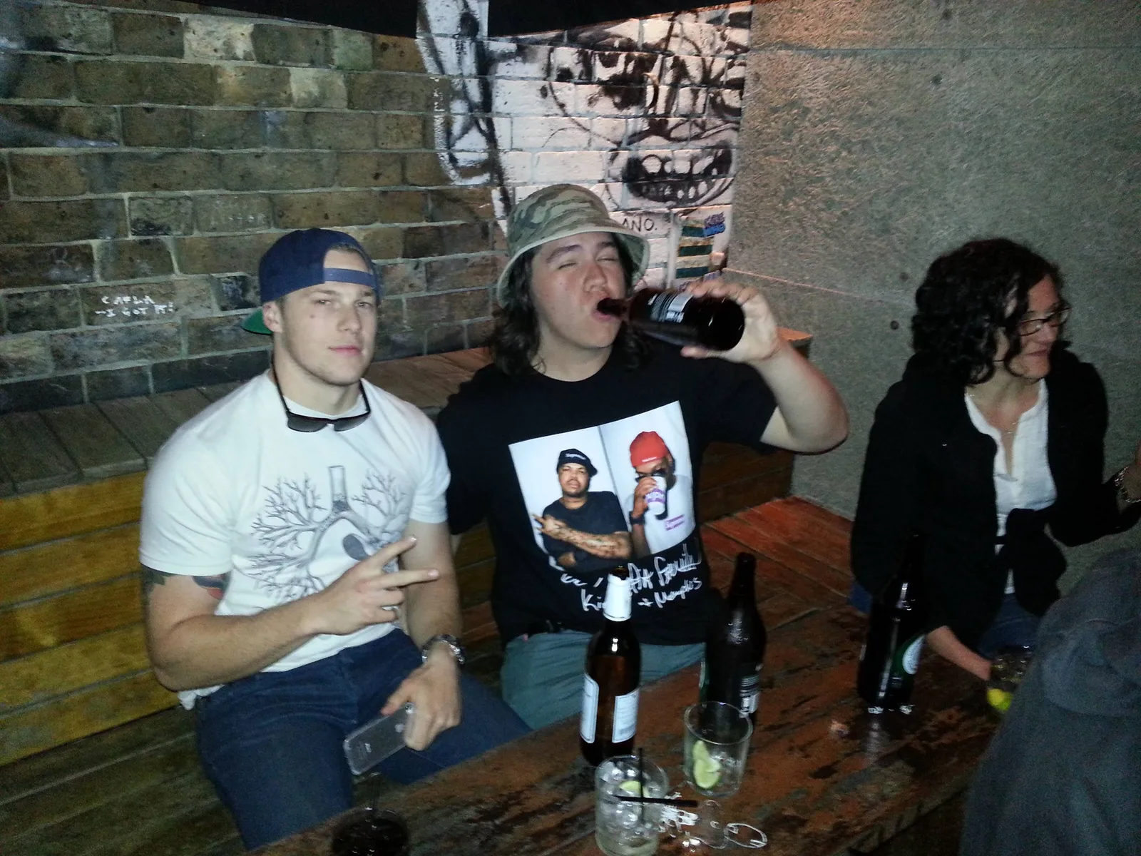 Group at a table with drinks in front of a graffiti wall at Ching-a-Lings