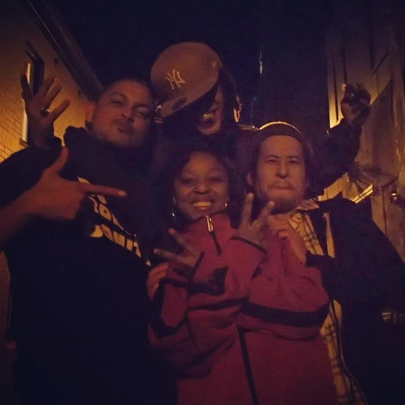 DJ CMAN, JuzzLikeDat and Makoto throwing hand signs together in a dark laneway.