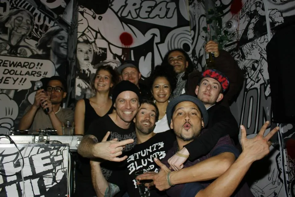 A crowd packed in front of a graffiti-covered wall at the snow jam