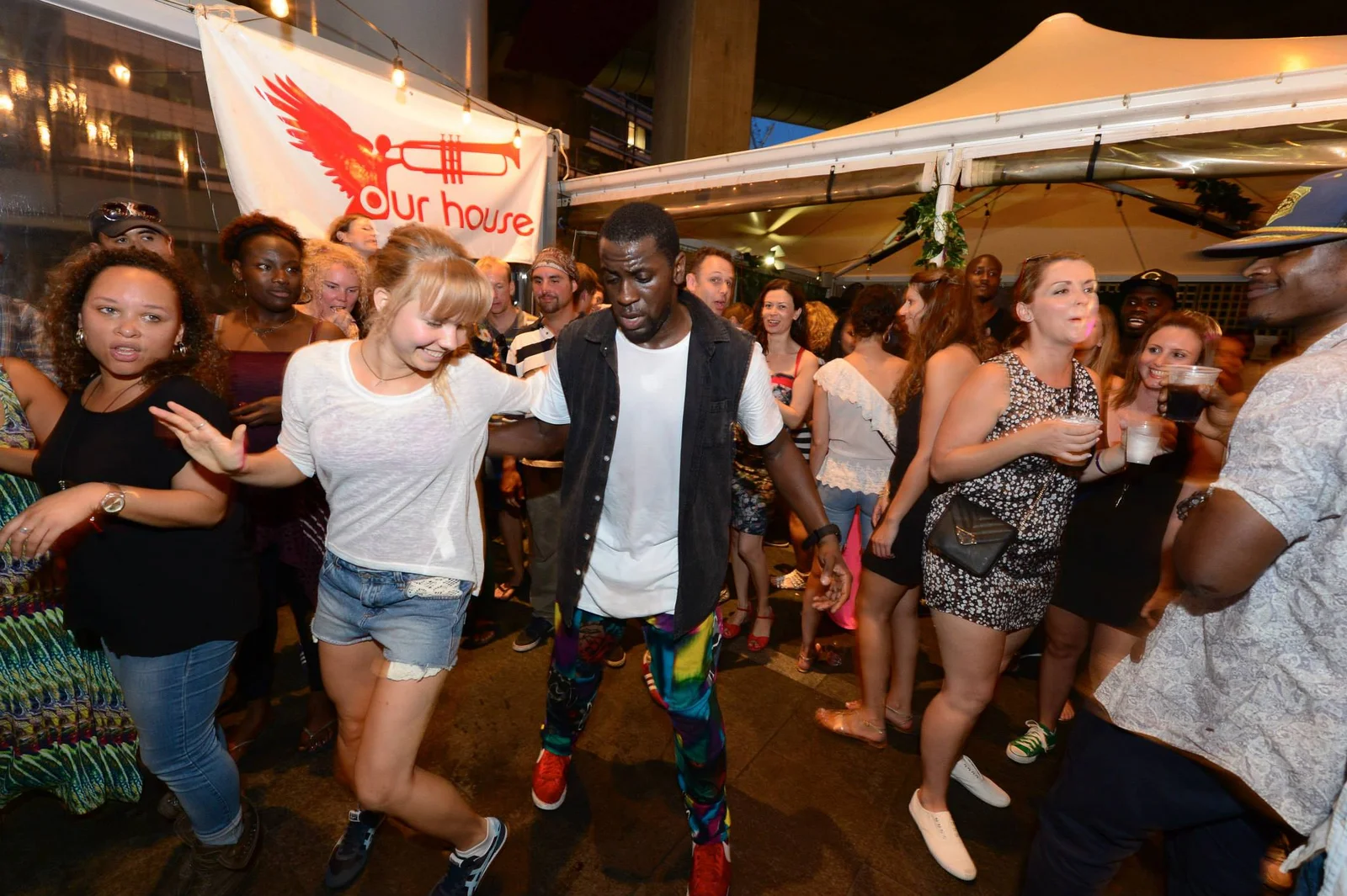 Photo from the Soul of Sydney NYD Block Party, Wednesday 1 January 2014, dancers in a circle under the Our House banner and marquee.