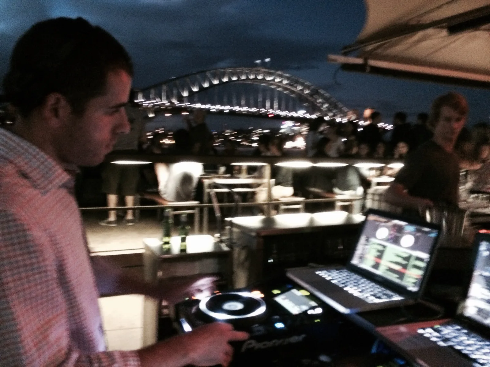Phil Toke at the decks at Opera Bar with the Sydney Harbour Bridge lit up behind