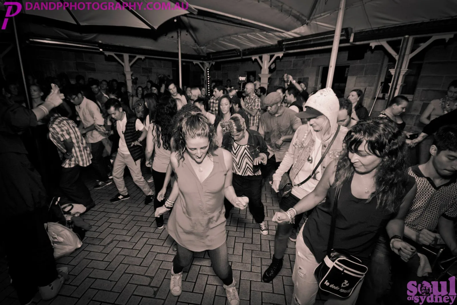 A black and white shot of the block party crowd with hands in the air