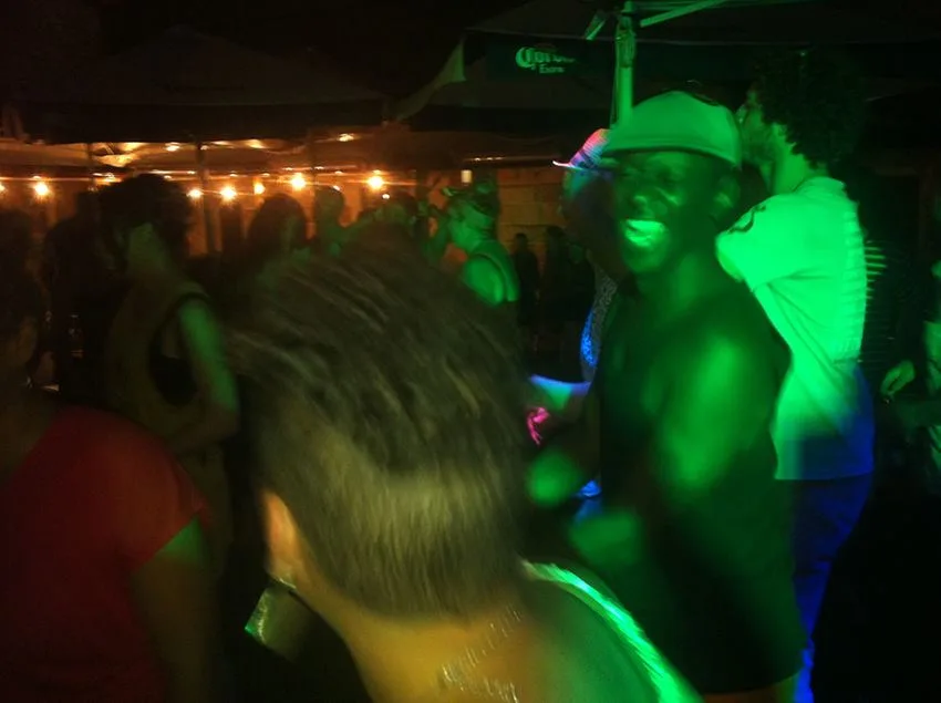 The crowd dancing under green light in the courtyard