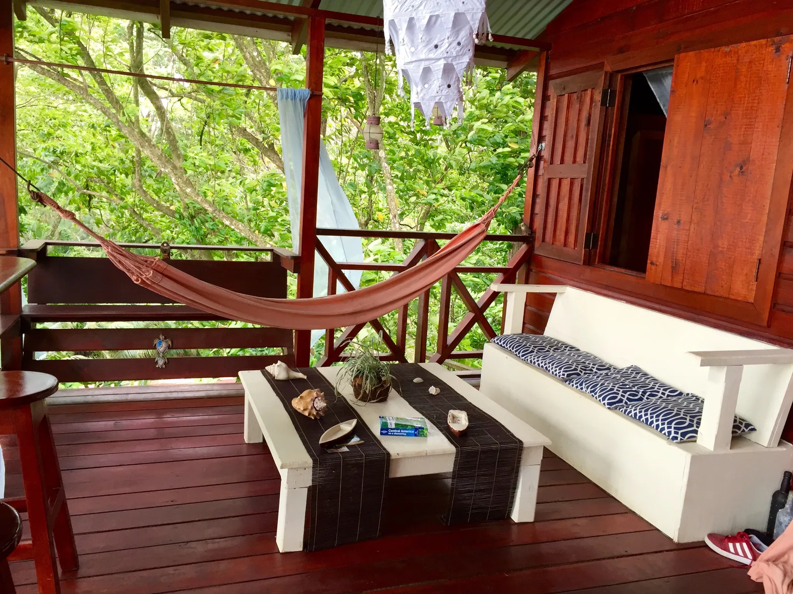 A shaded verandah with a hammock strung across it at a guesthouse