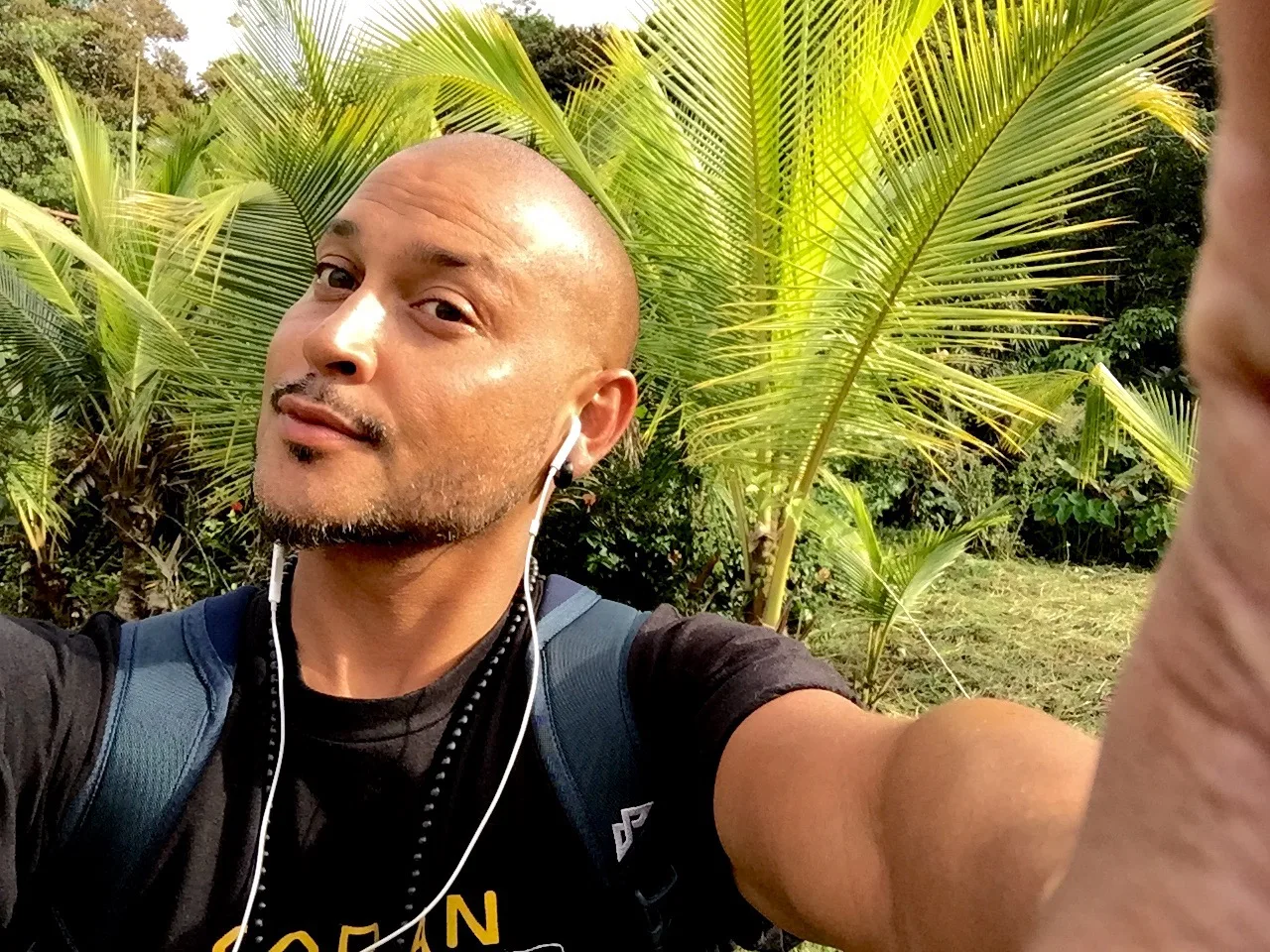 DJ CMAN outdoors in front of dense green jungle on the Central America trip
