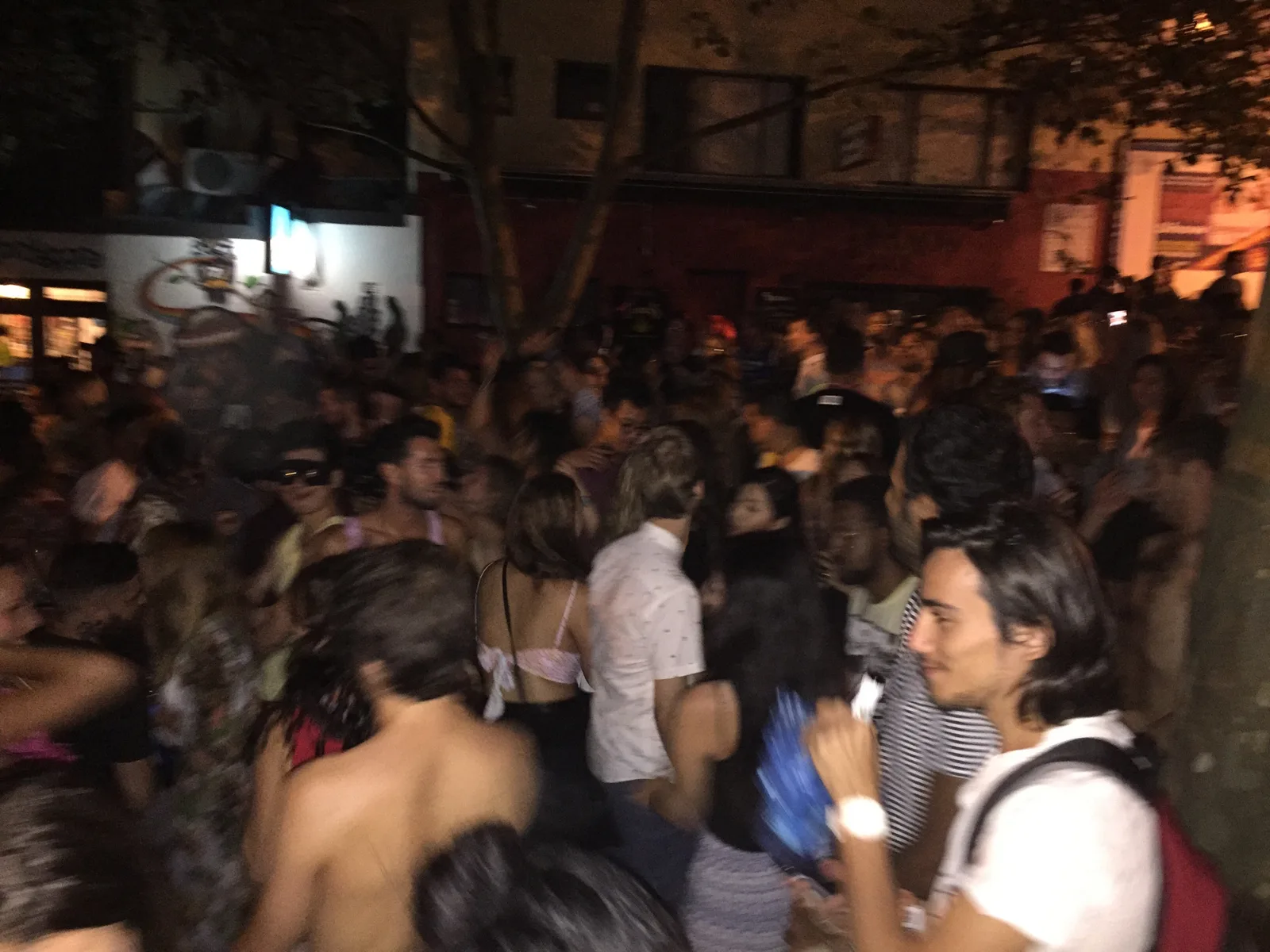 A packed street crowd on the corner outside during the Mardi Gras street party in Surry Hills