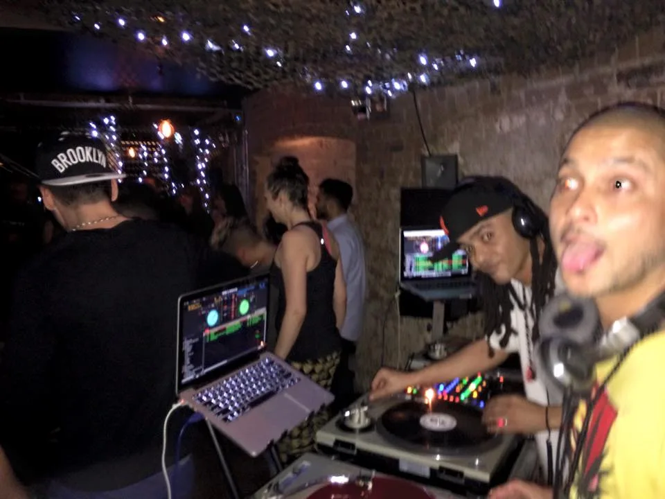 Two DJs behind the booth at Play Bar late in the night