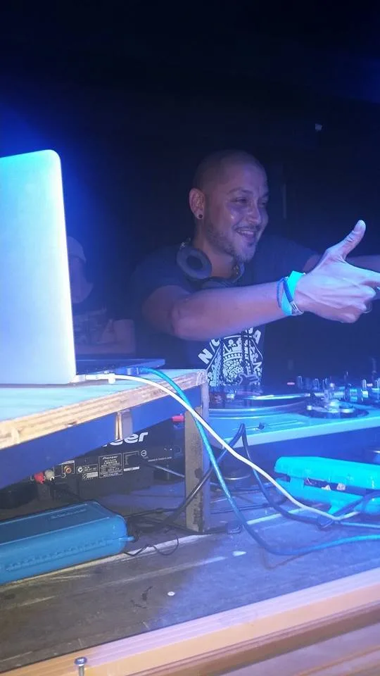 A DJ lit blue behind the decks at the Jam Gallery