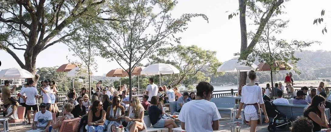 A crowd spread across the lawn under trees at the Newport