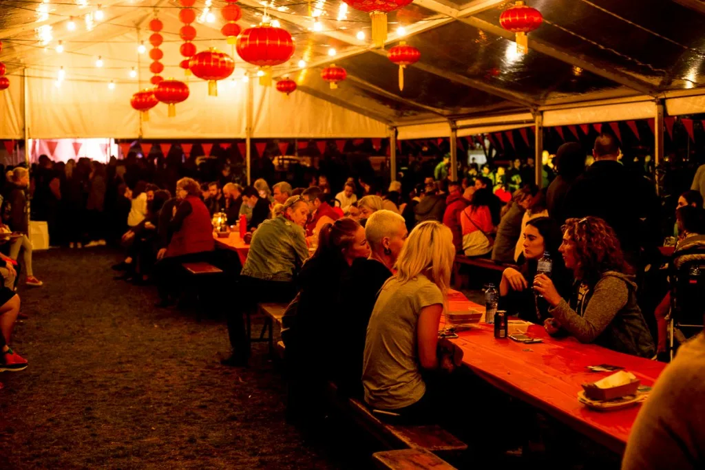 A busy night noodle market under red lanterns
