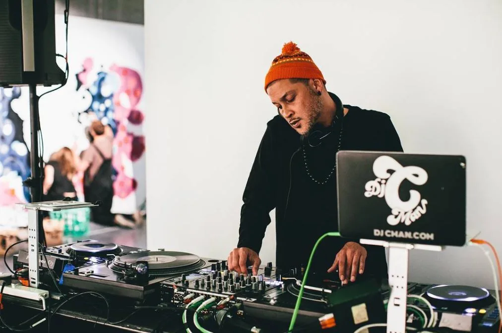A DJ playing beside the artists at the Secret Walls live art event