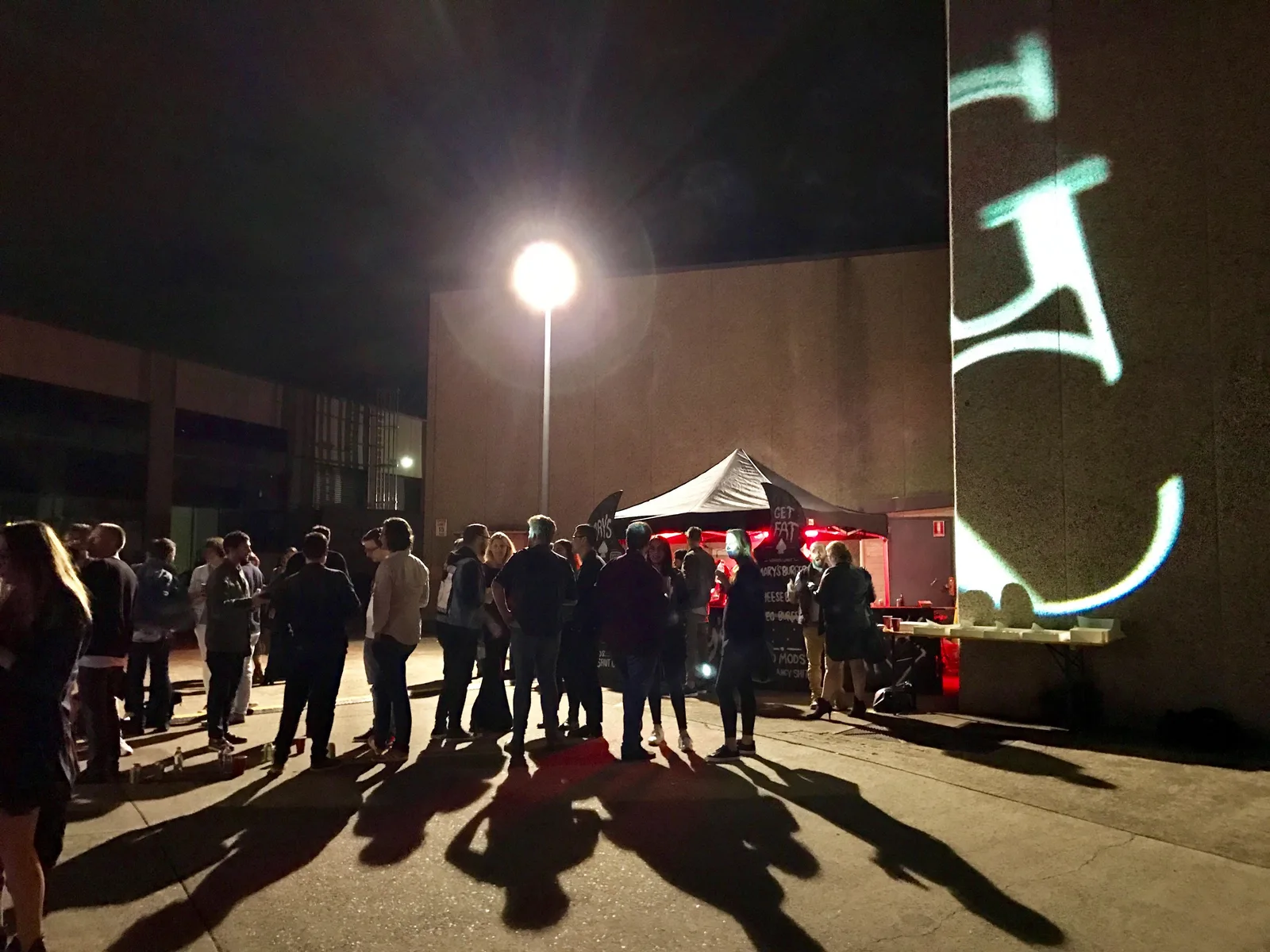 Light trails over the crowd outside the live art event at night