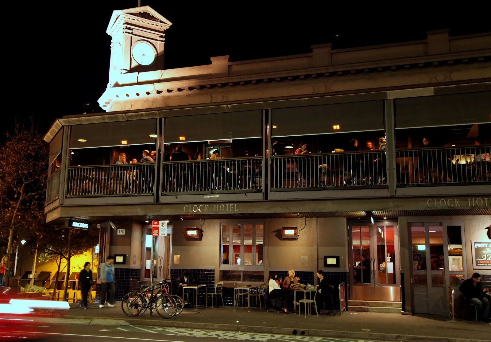 The Clock Hotel lit up on the corner at night