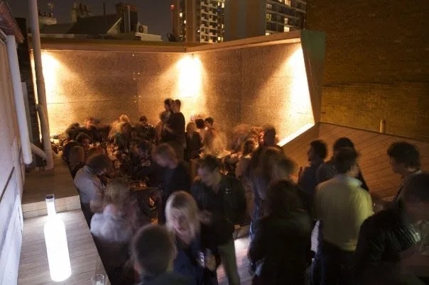 Crowd in the walled courtyard at Ching-a-Lings on Oxford Street at night