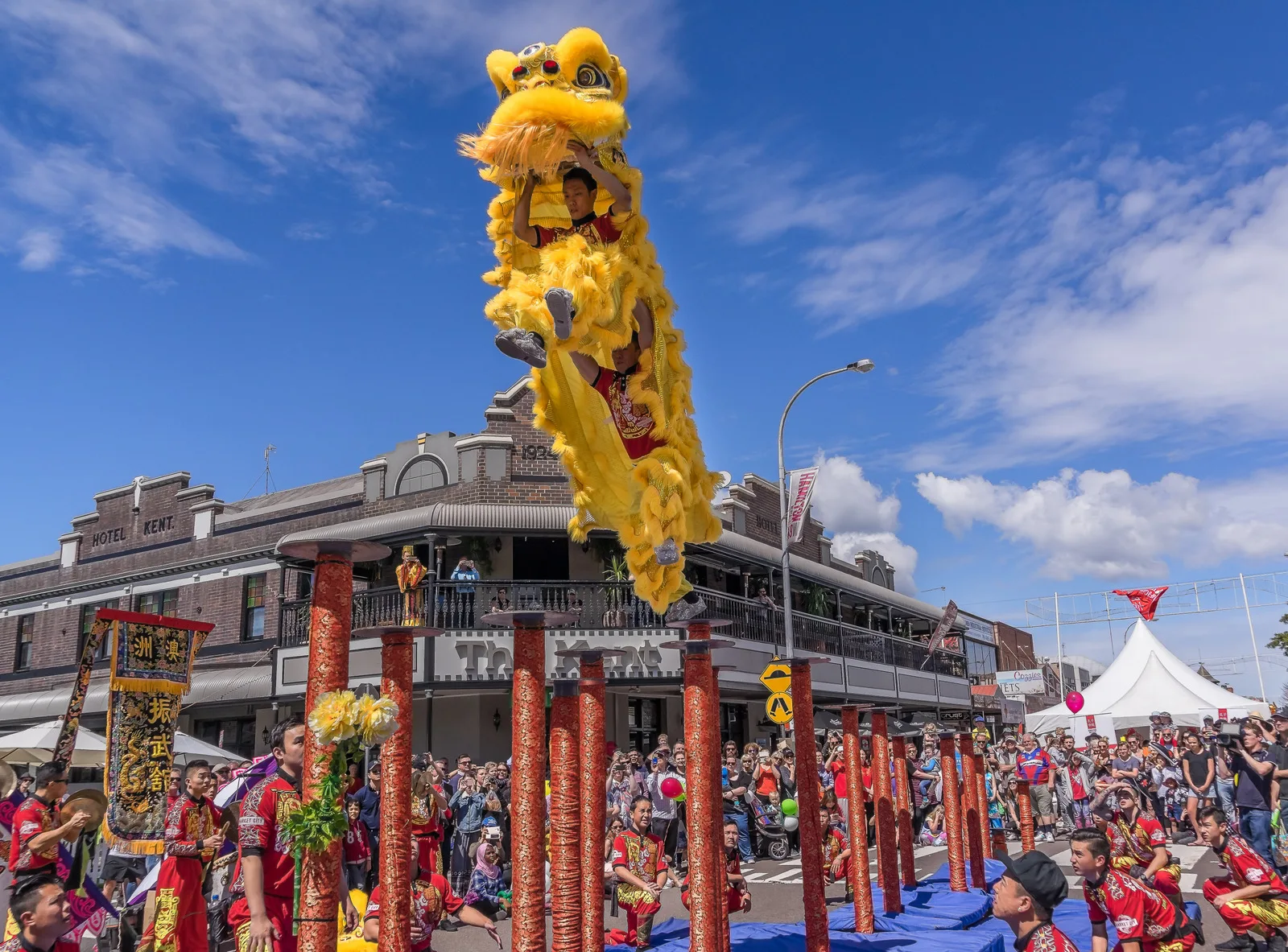 A golden lion dance costume raised above the street festival crowd