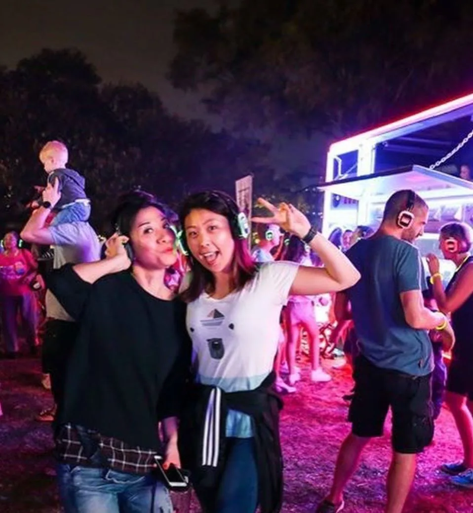 People dancing outdoors at night under coloured light