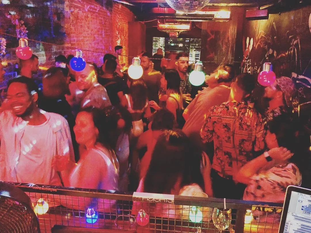 A packed bar under red light at the Moonshine Music Jam