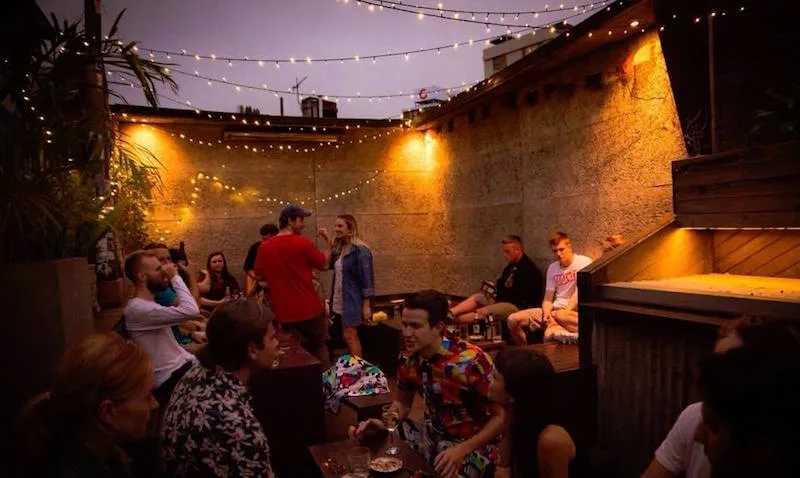 An outdoor courtyard busy at night with festoon lighting