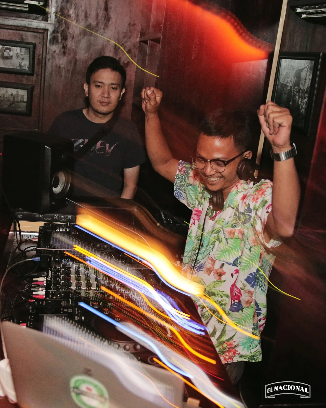 Two DJs in the booth at El Nacional, Seminyak, with light trails streaking across the mixer
