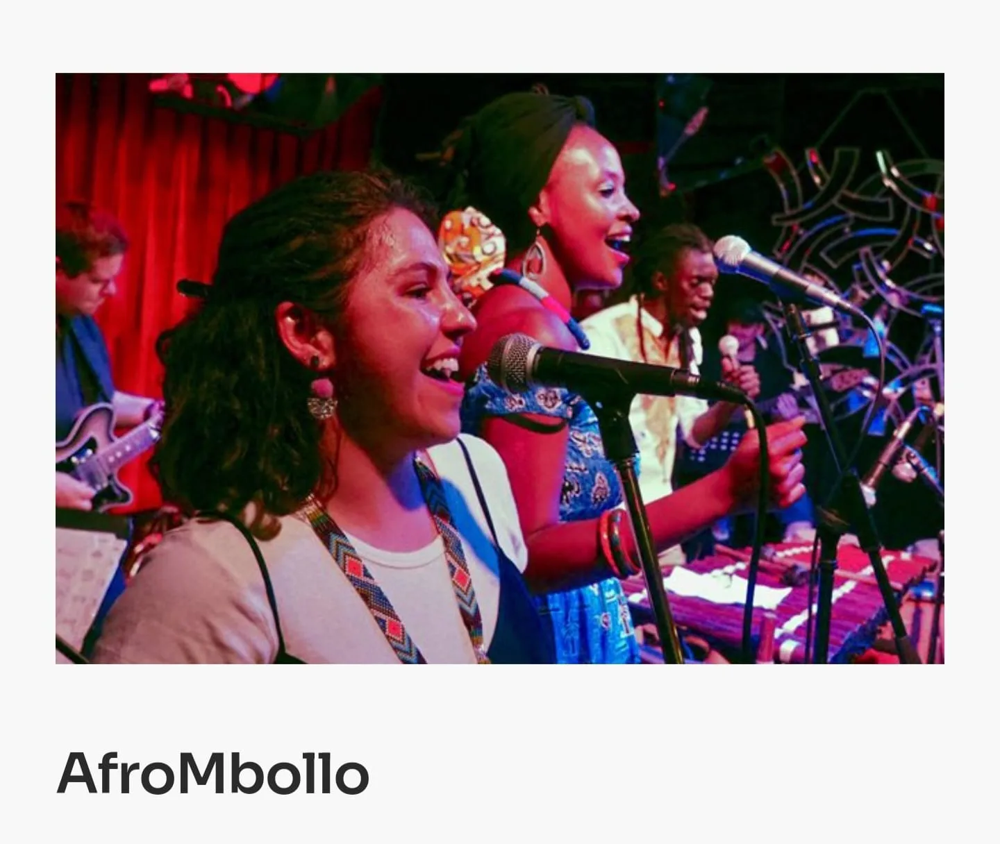 Vocalists from AfroMbollo singing together on stage