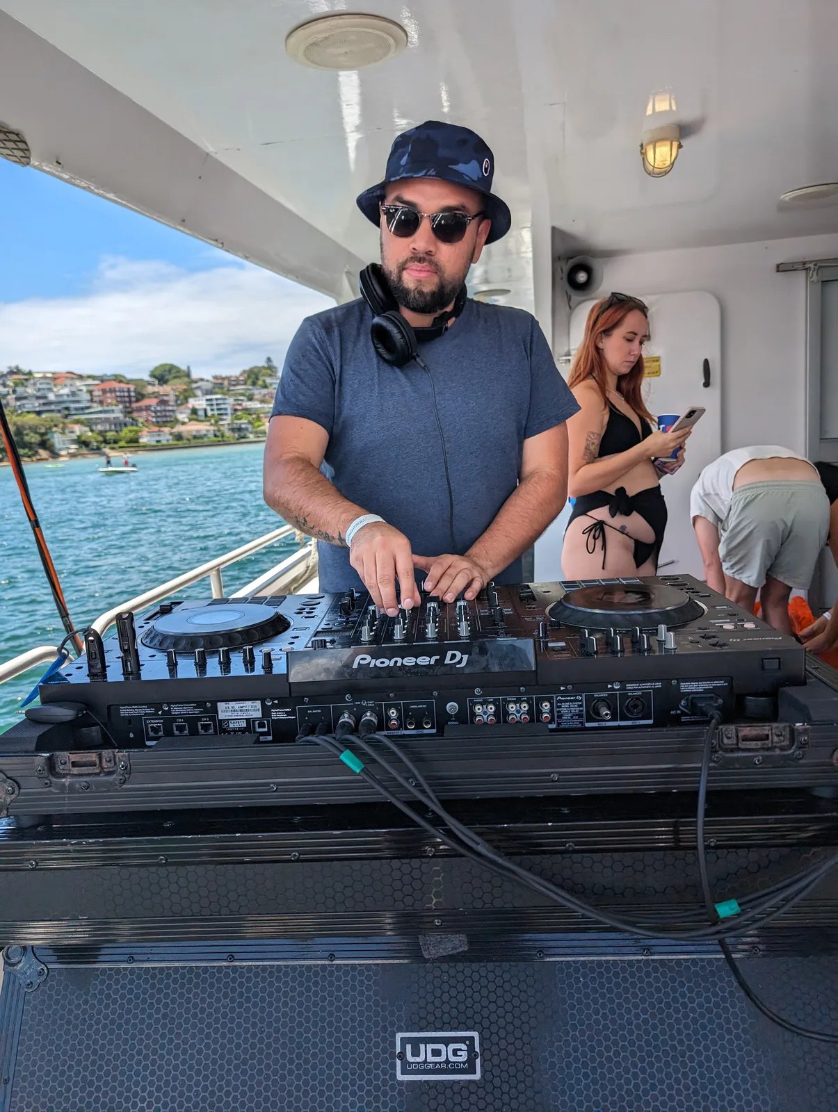 Mo'funk on the decks at The Yacht Social Club, Sydney Harbour behind him.