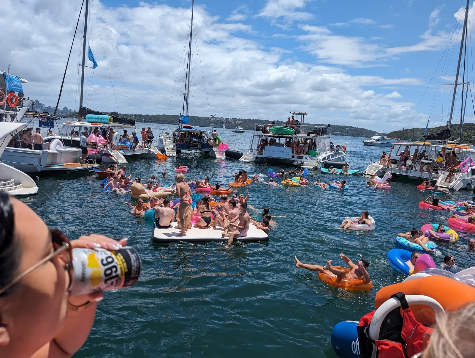 The Yacht Social Club raft-up on Sydney Harbour - boats circled with swimmers and floats in the middle.